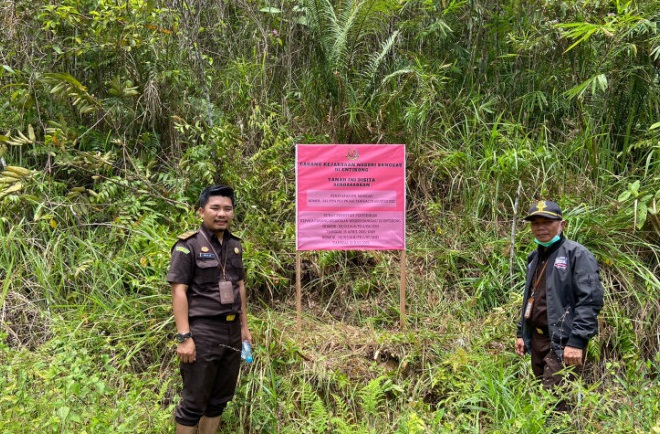 Petugas Kejari memasang papan nama di tanah milik tersangka FY di Kecamatan Sekayam, Kabupaten Sanggau.